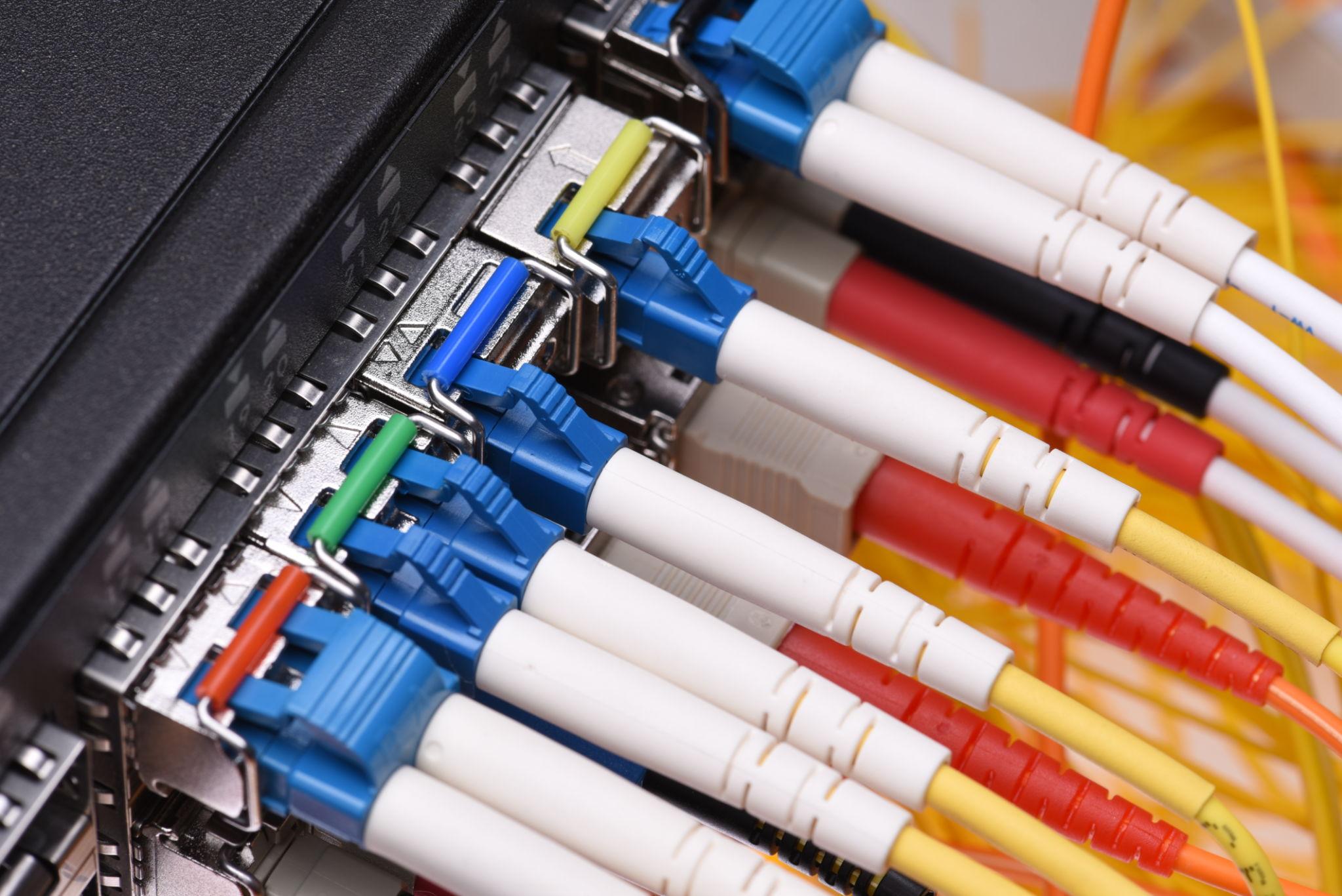 Close-up of fiber optic cables connected to network switch for high-speed data transmission